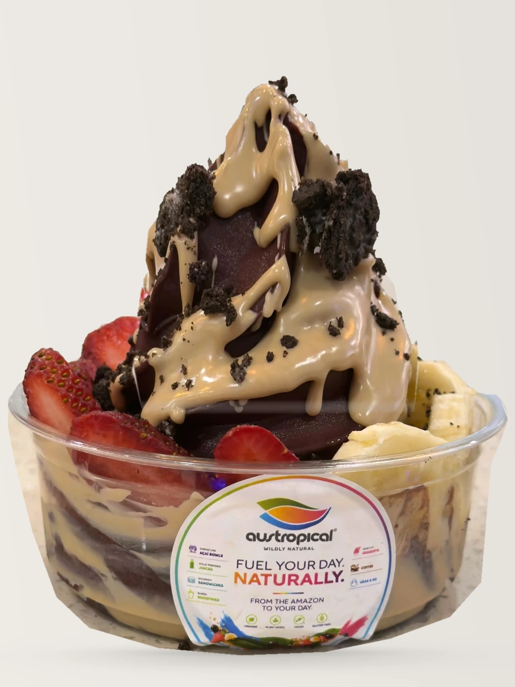 An açaí bowl with a creamy sauce and cookie crumbs over strawberries and banana.
